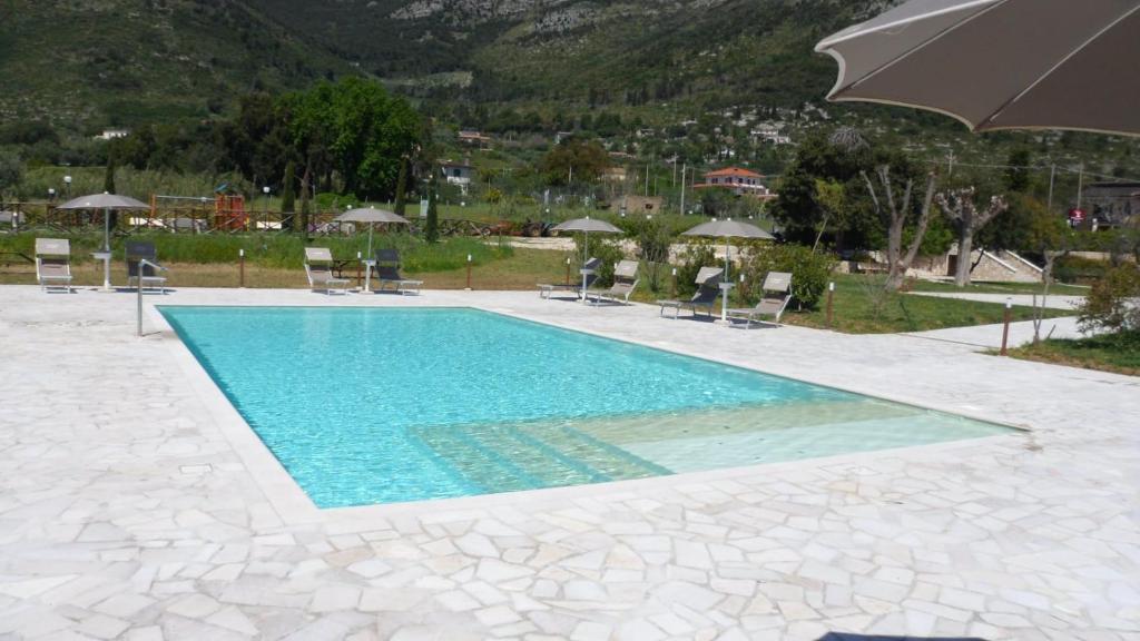 - une piscine avec des chaises et un parasol dans l'établissement Il Sentiero di Leano, à Terracine