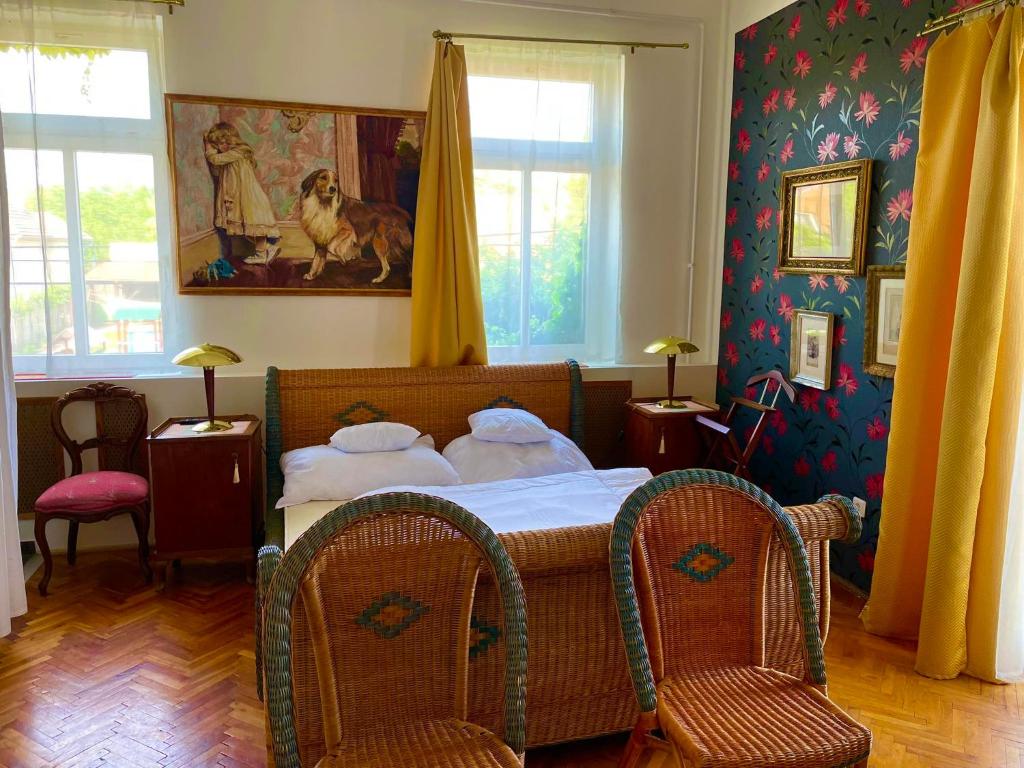 een slaapkamer met een bed en 2 stoelen bij Villa Luca in Mosonmagyaróvár