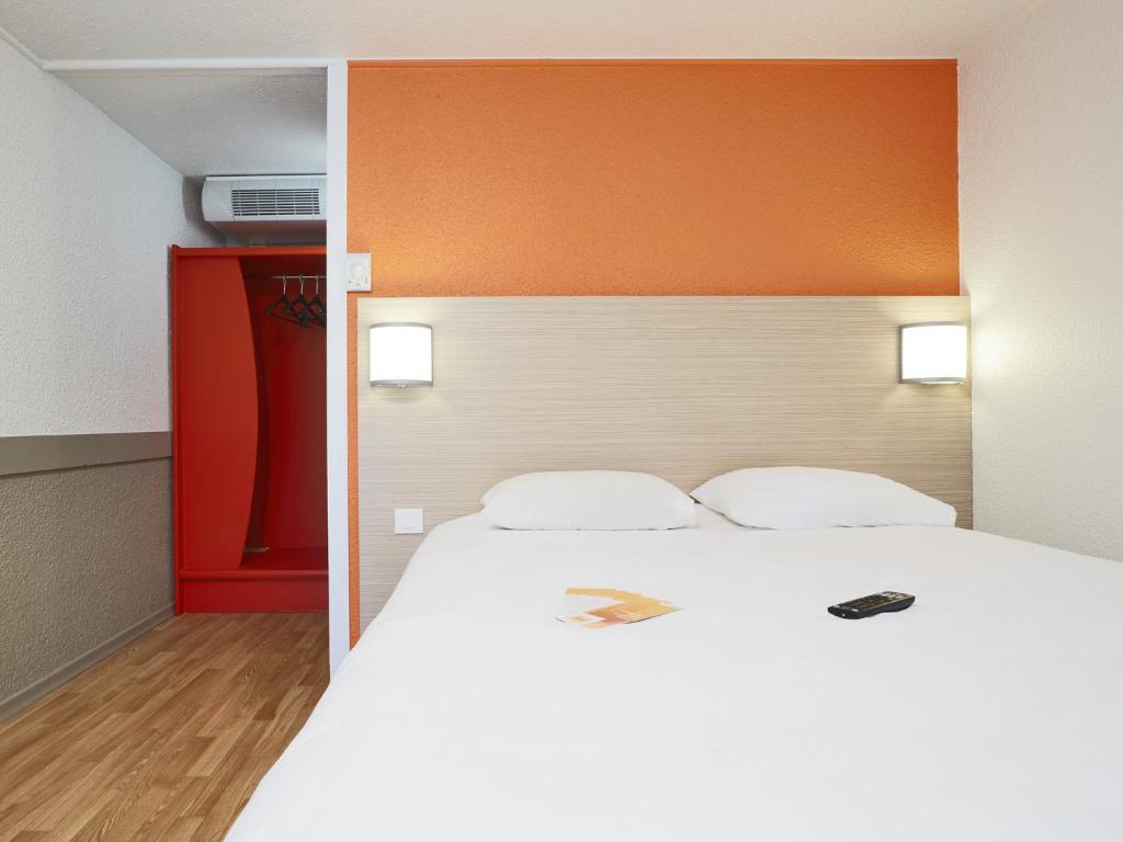 een slaapkamer met een groot wit bed met een oranje hoofdeinde bij Premiere Classe Poitiers Futuroscope - Chasseneuil in Chasseneuil-du-Poitou