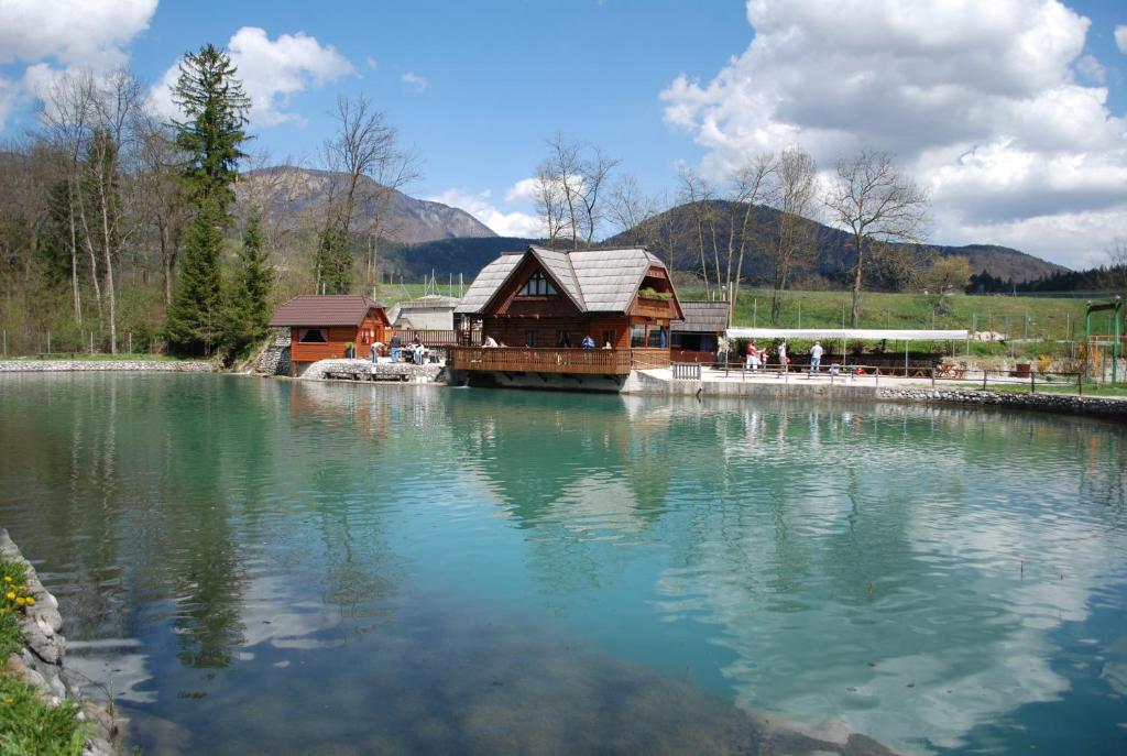 un grand lac avec un bâtiment au milieu dans l'établissement Apartma Mihovc, à Kamnik