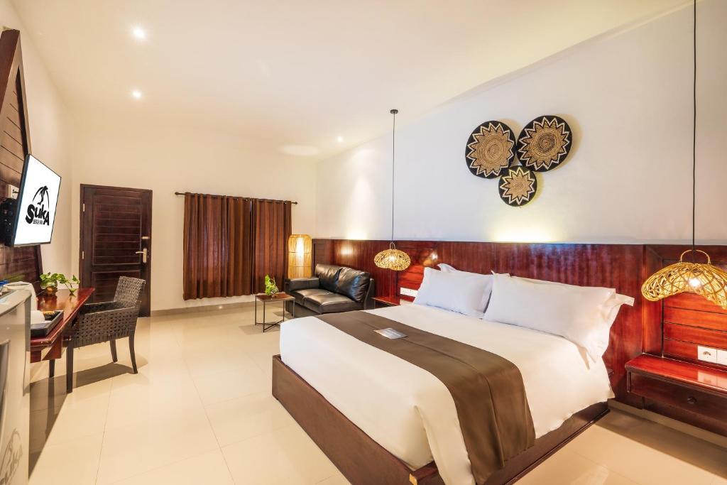 a bedroom with a bed and a living room at Suka Beach Inn in Kuta