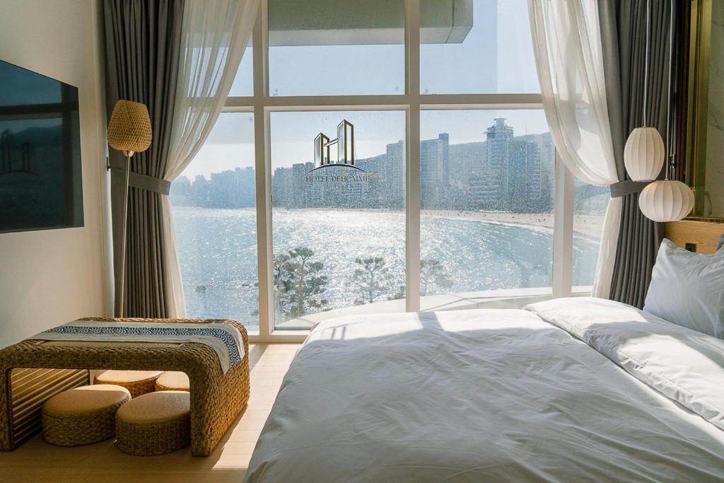 Dormitorio con ventana grande con vistas al agua en De Homme Hotel, en Busan