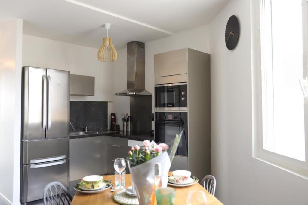 a kitchen with a table with flowers on it at Très Belle MAISON à Rennes St Jacques in Saint-Jacques-de-la-Lande