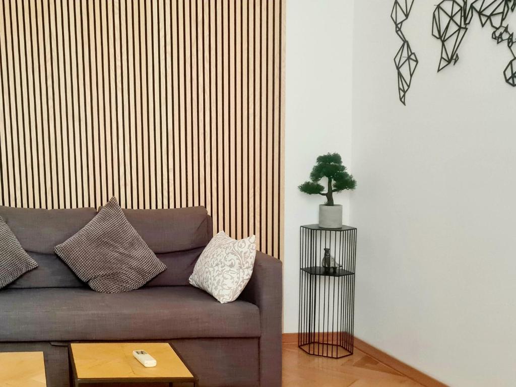 a living room with a couch and a plant on a wall at Cicibela Apartment - Zadar in Zadar