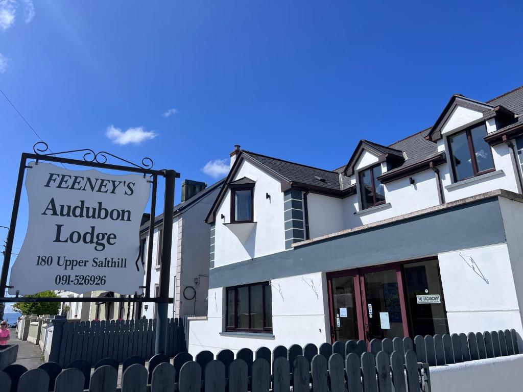 a white building with a sign in front of it at Feeney's Audubon Lodge in Galway