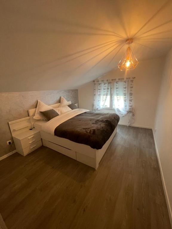 een slaapkamer met een groot bed en een raam bij Maisonnette avec terrasse in Straatsburg