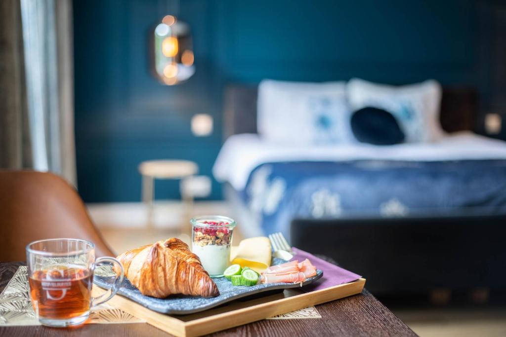 einen Teller mit Essen auf einem Tisch mit einem Bett in der Unterkunft Heuvelsuites in Oosterhout