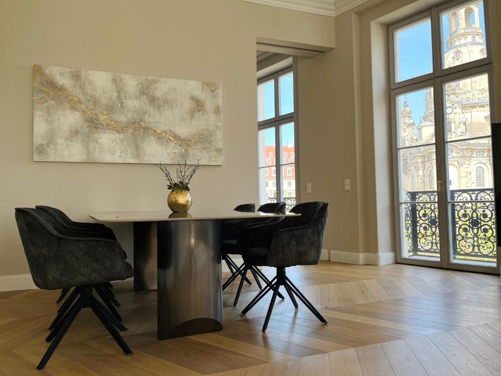 een eetkamer met een tafel en vier stoelen bij Luxury Home / 3-Raum-Suite an der Frauenkirche / 4 in Dresden