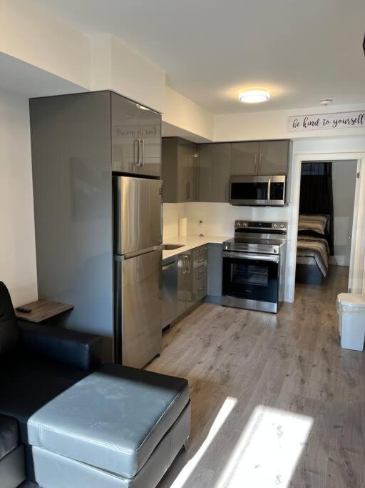 una cucina con elettrodomestici in acciaio inossidabile e un soggiorno di Lovely one bedroom condo with free parking a Niagara Falls