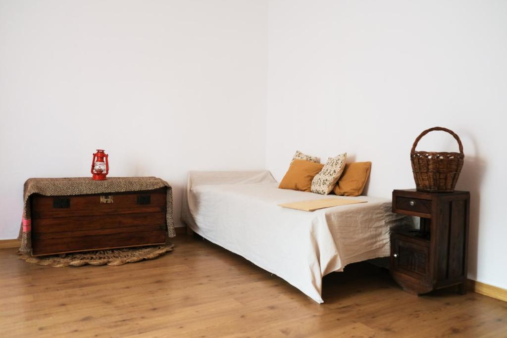 - une chambre avec un lit blanc et une table de nuit dans l'établissement Além Tejo Guesthouse, à Mértola