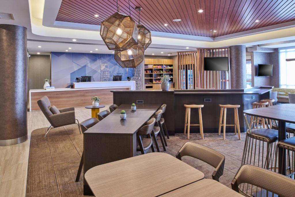 SpringHill Suites by Marriott Detroit Dearborn في ديربورن: مطعم بطاولات وكراسي وبار