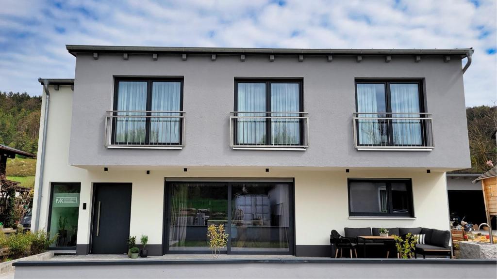 une maison blanche avec des fenêtres noires dans l'établissement MK Appartements, à Bad Abbach