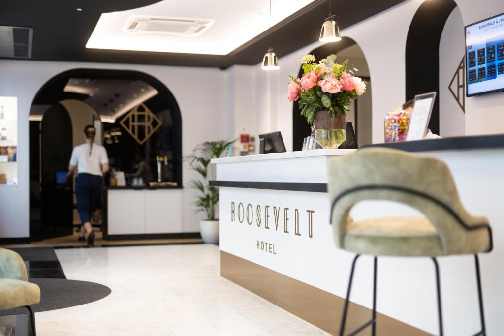 un negozio con un bancone con un vaso di fiori di Hôtel Le Roosevelt Lyon a Lione