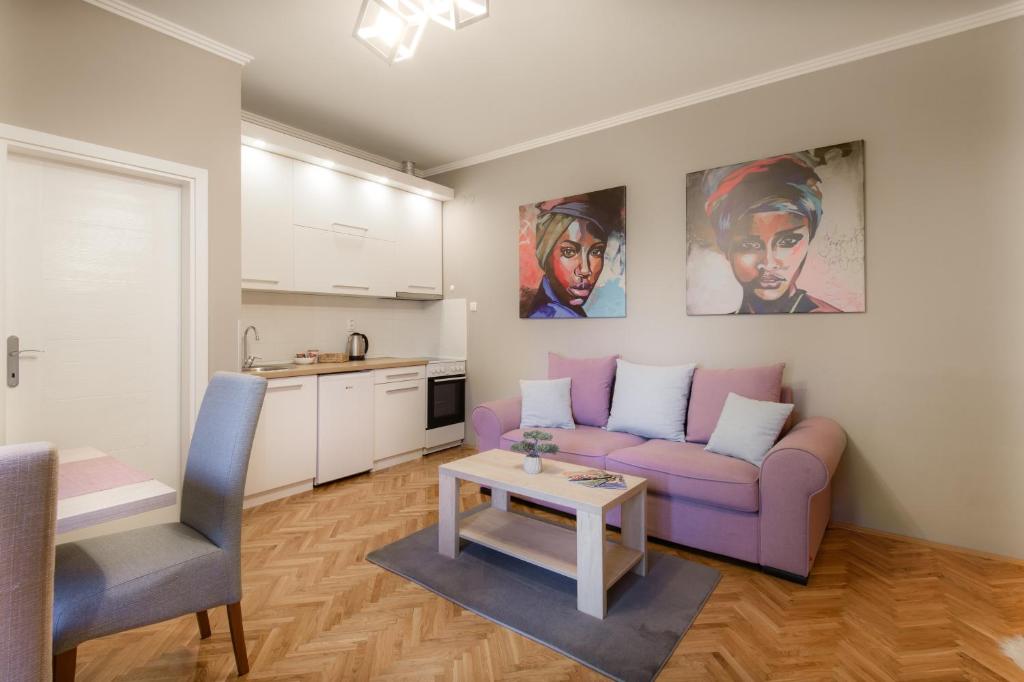 a living room with a purple couch and a table at DuMalux Velvet in Subotica