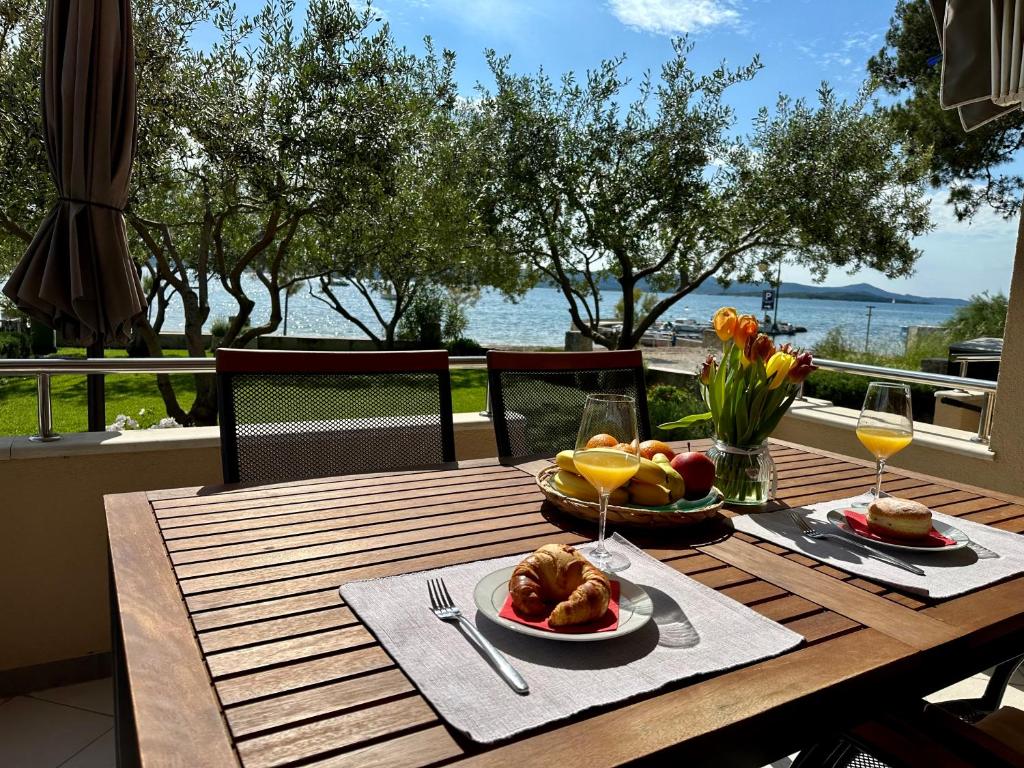 a wooden table with a plate of food on it at Apartmani Roko in Biograd na Moru