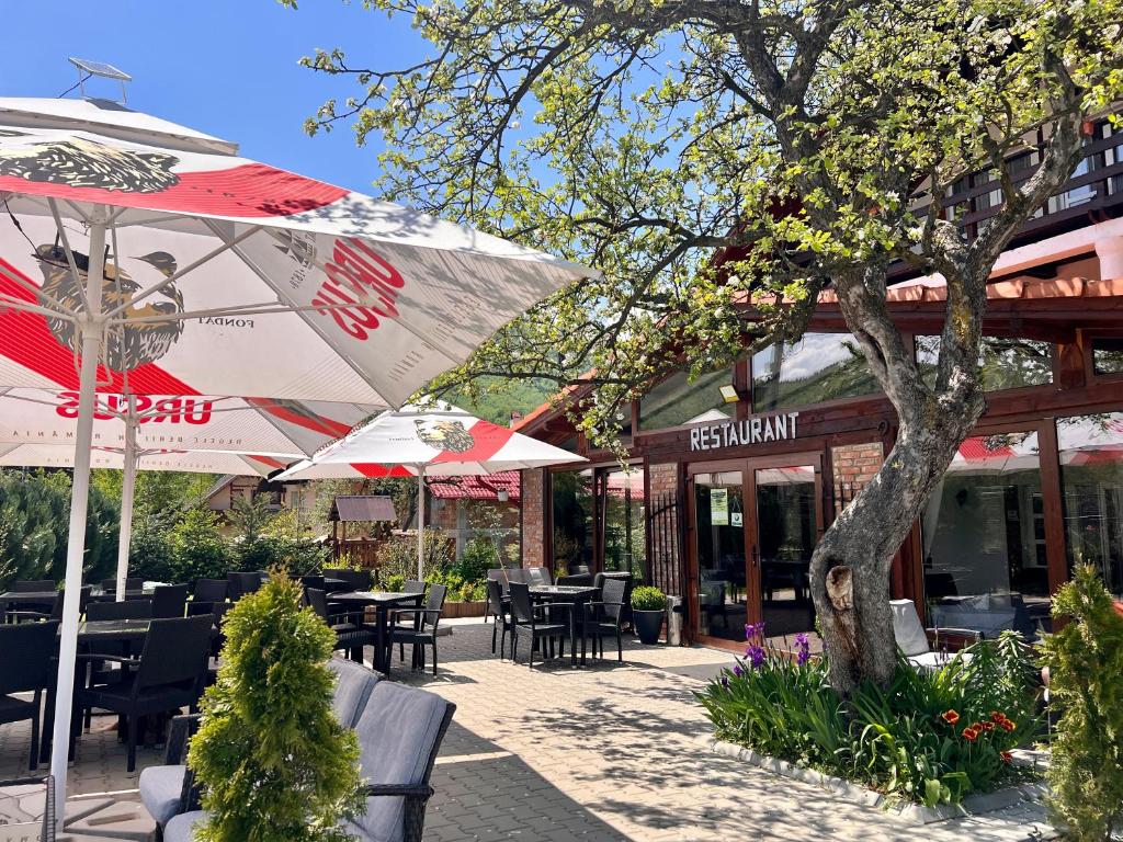 um pátio com mesas e guarda-sóis em frente a um restaurante em Casa Cenţiu em Bran