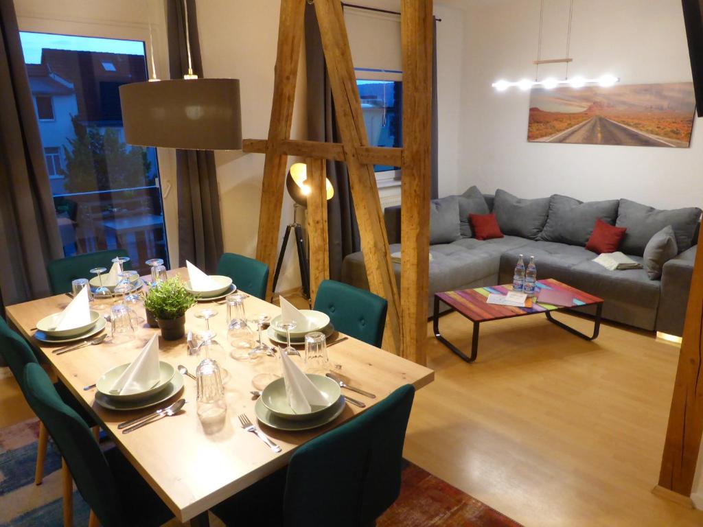 una sala da pranzo con tavolo e divano di Jena City Apartment, Balkon, sonnig, Wifi, Parkplätze, Nähe Zentrum a Jena