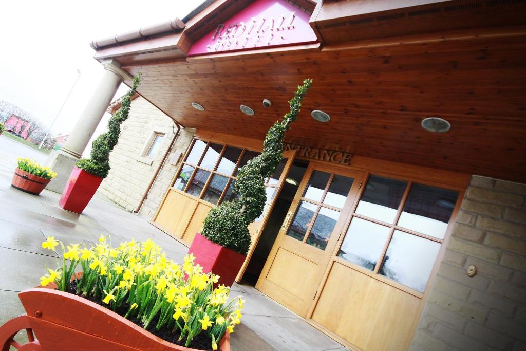 un restaurant avec des fleurs devant un bâtiment dans l'établissement Red Hall Hotel, à Walmersley