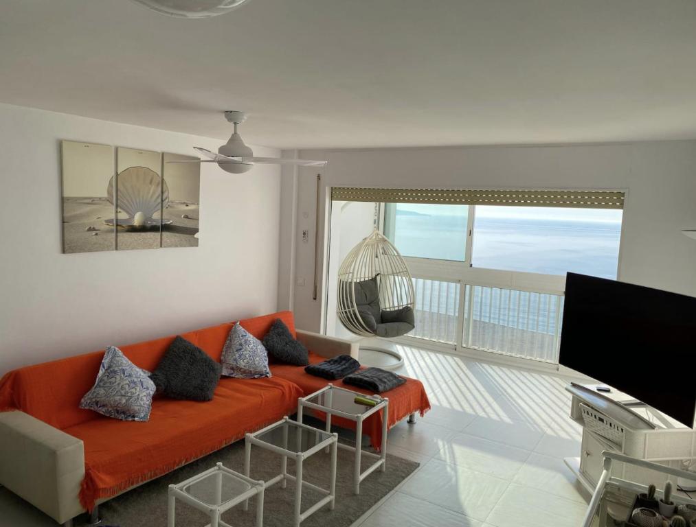 ein Wohnzimmer mit einem orangenen Sofa und einem Balkon in der Unterkunft Manhattan apartment in Empuriabrava