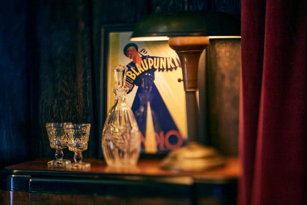 a table with two glasses and a vase on it at Crew's Quarters Boarding House - Caters to Men in Provincetown