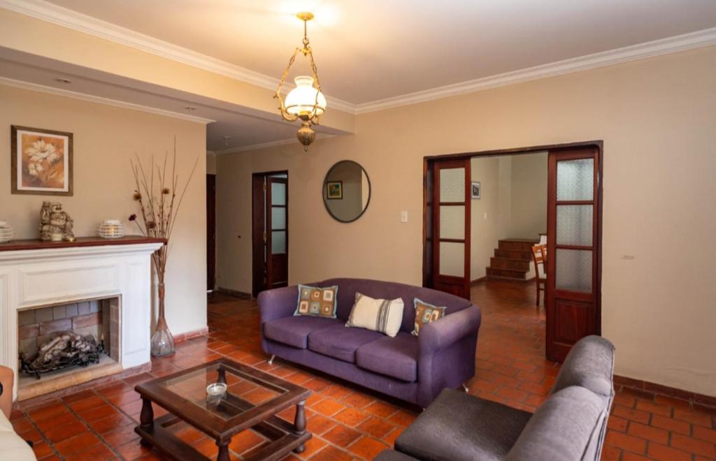 a living room with a purple couch and a fireplace at Casa Salta in Salta