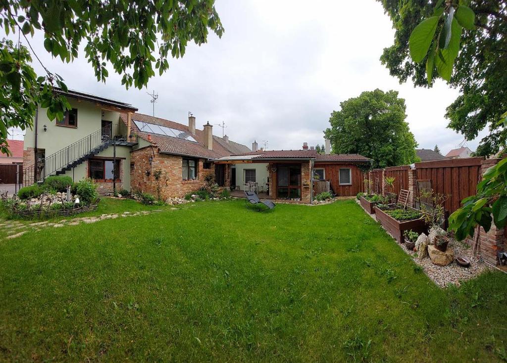 un cortile di una casa con un cortile con prato verde di Apartmá U rybníčku a Dolní Dunajovice