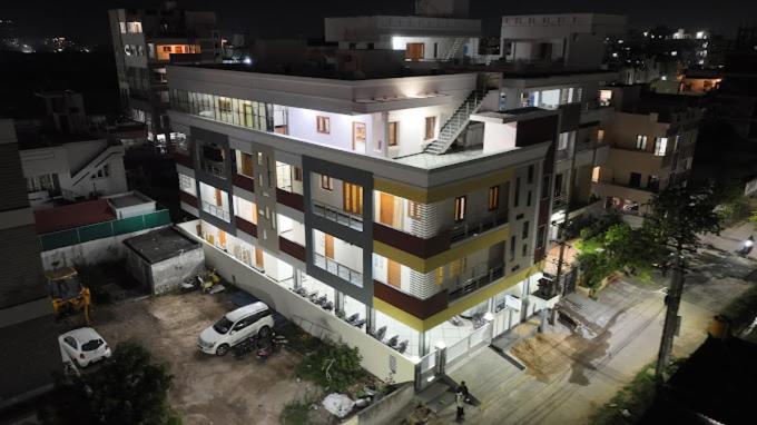 un edificio con un'auto parcheggiata di fronte di Padma Homes Stay- Luxury Service Apartment 1BHK & 2BHK & 3BHK a Tirupati