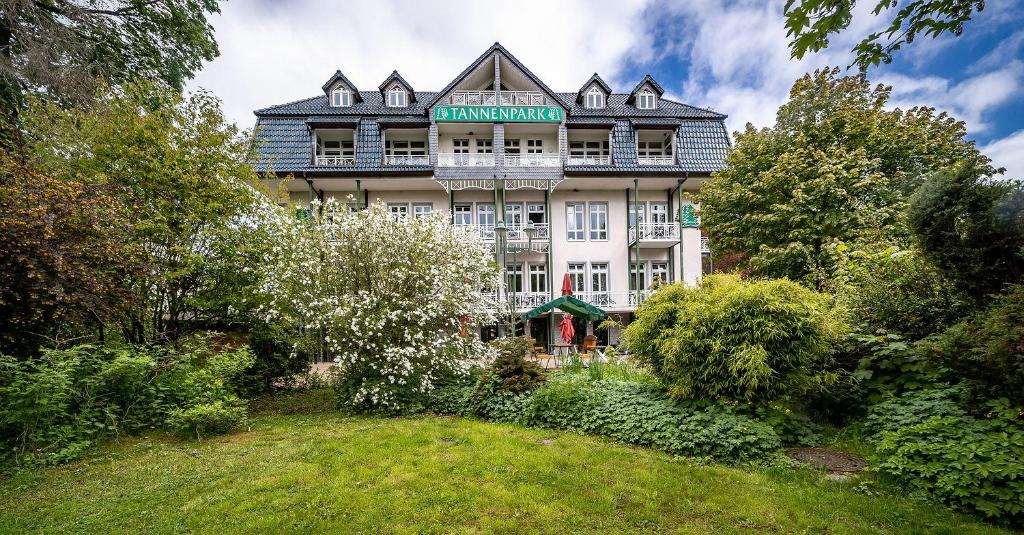 a large white building with a green sign on it at Appartement-Hotel-Anlage Tannenpark in Tanne