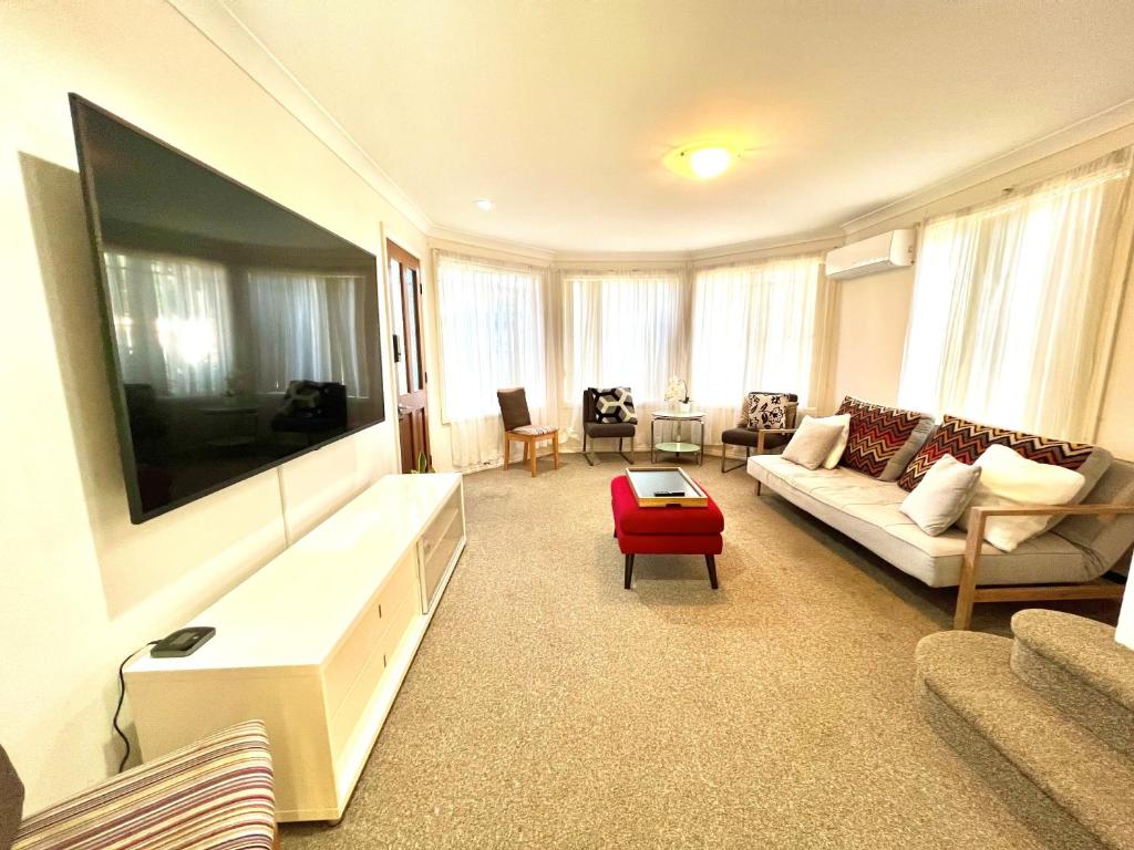 ein Wohnzimmer mit einem großen Flachbild-TV in der Unterkunft 3 Bedroom Town house near Gosford CBD Sleeps 6 plus in Gosford