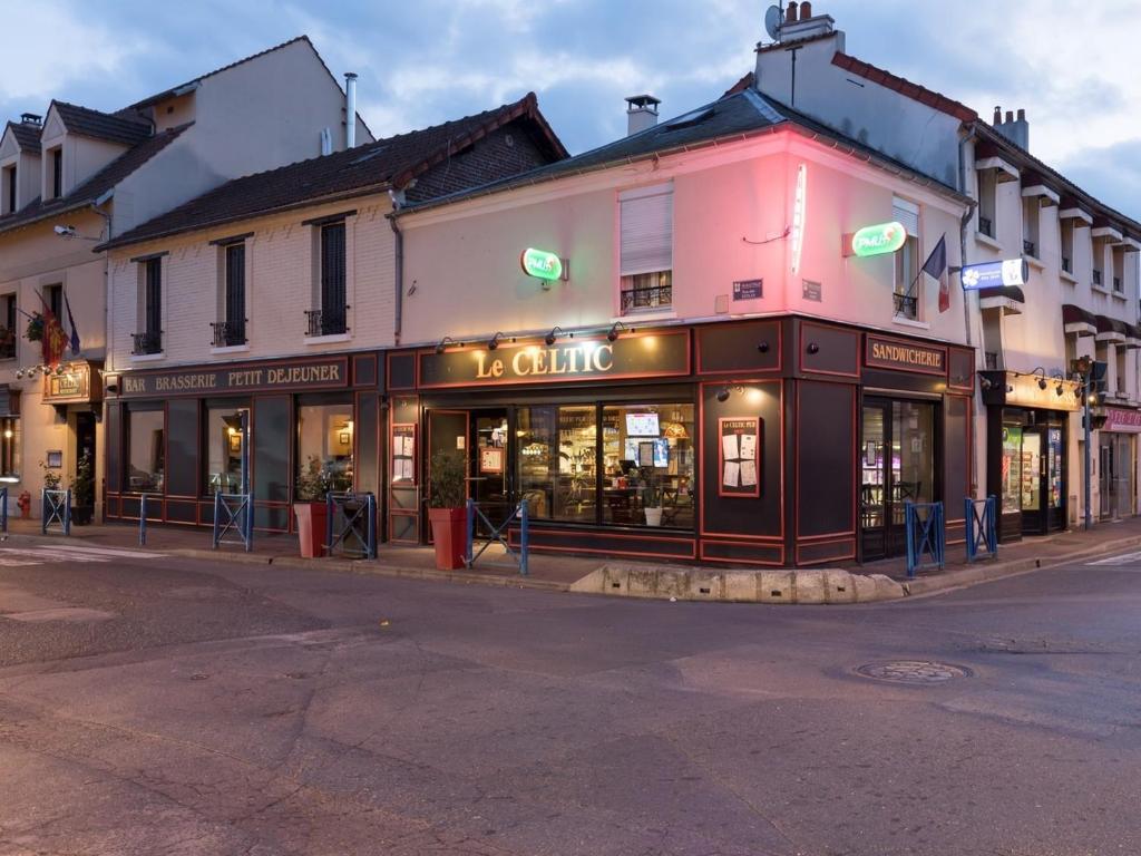 un coin rue avec un magasin dans une rue de la ville dans l'établissement Le Celtic, à Le Thillay