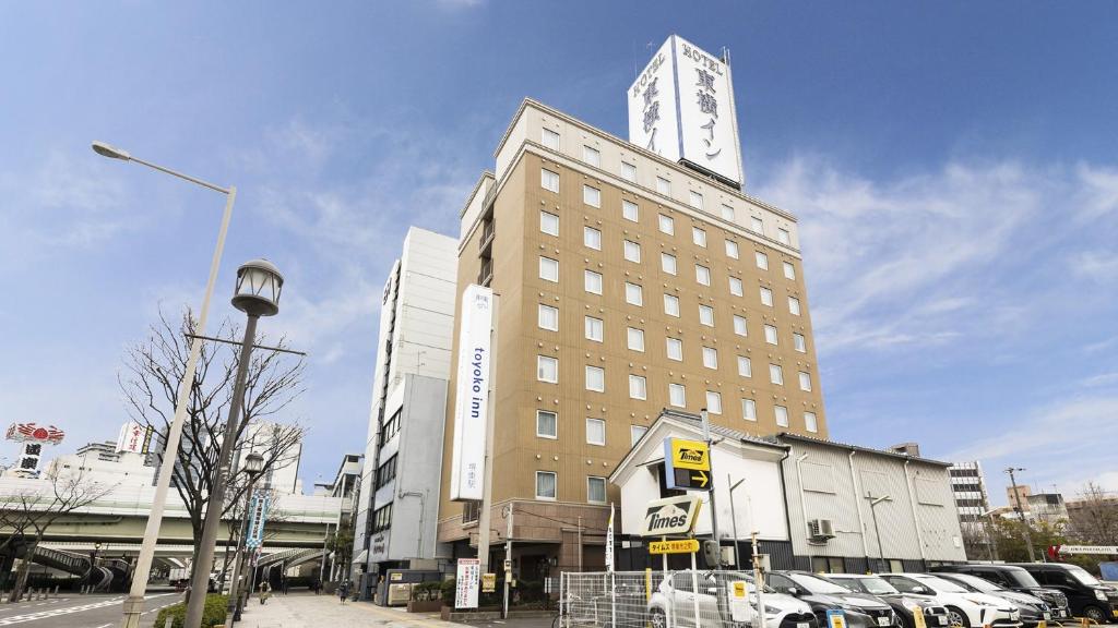 堺市Toyoko Inn Osaka Sakai-higashi-eki的一座高大的建筑,上面有一个钟楼