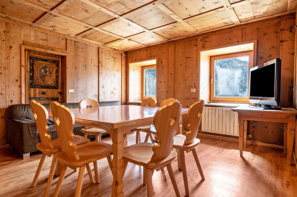 uma sala de jantar com uma mesa de madeira e cadeiras em Muncion Apparte em Pozza di Fassa