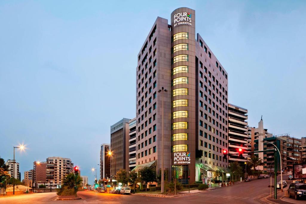 een hoog gebouw in een stadsstraat bij zonsondergang bij Four Points By Sheraton Le Verdun in Beiroet