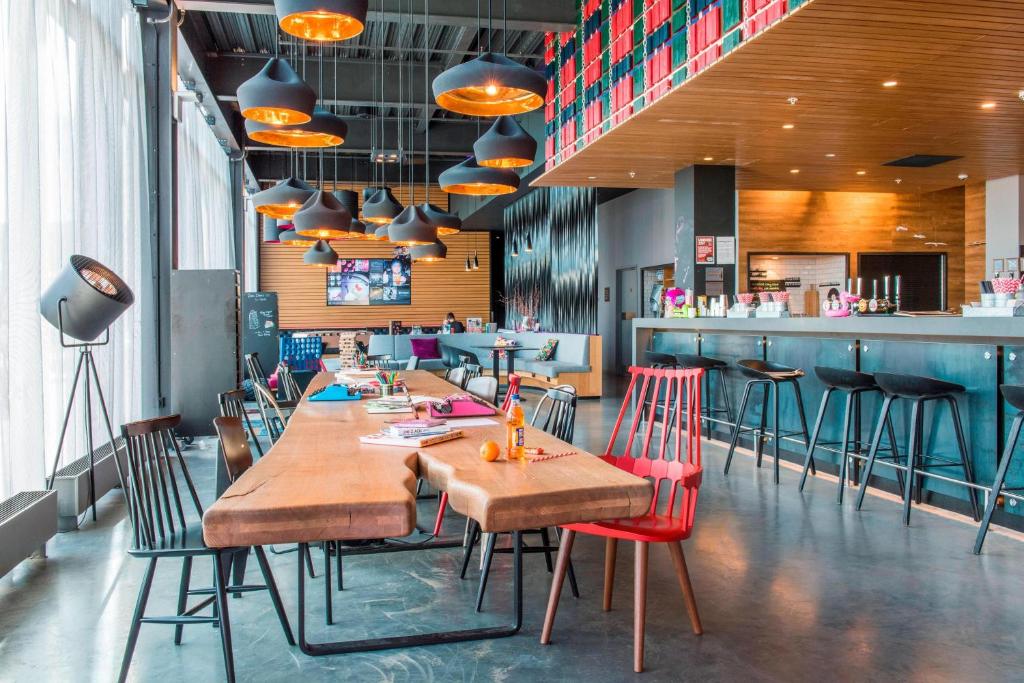 un restaurante con mesas y sillas y un bar en Moxy Aberdeen Airport, en Dyce