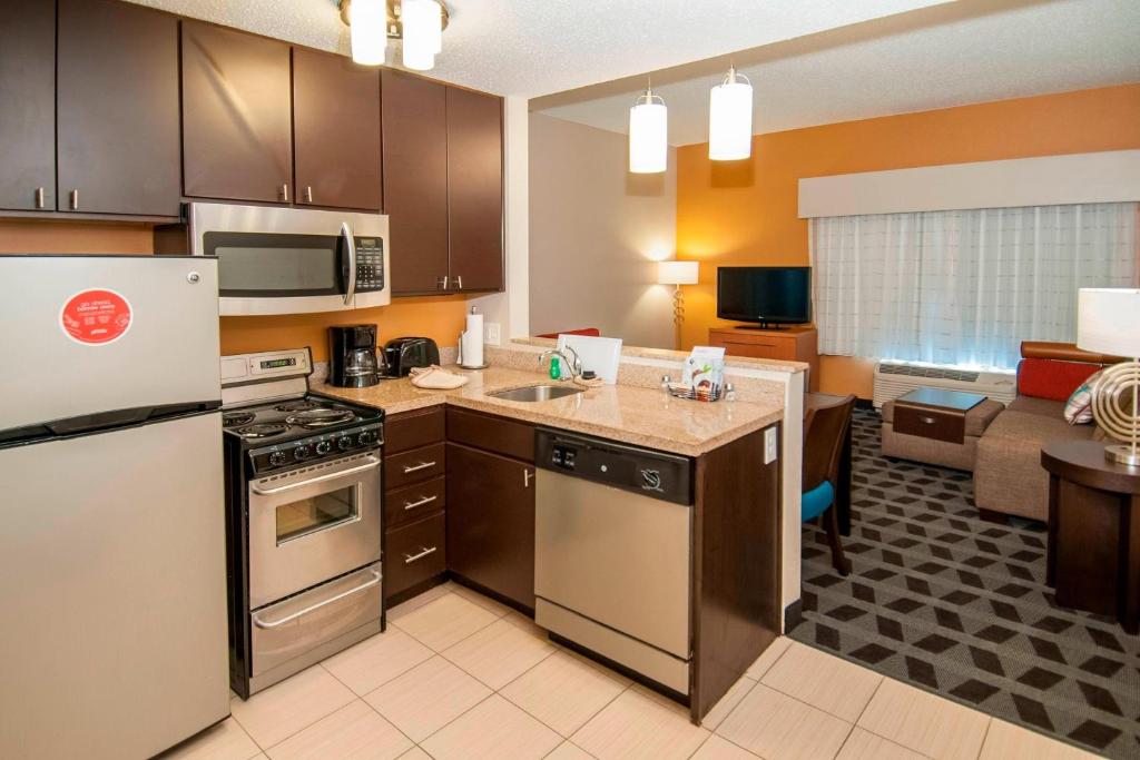 una cucina con elettrodomestici in acciaio inossidabile e un soggiorno di TownePlace Suites by Marriott Baton Rouge Gonzales a Gonzales