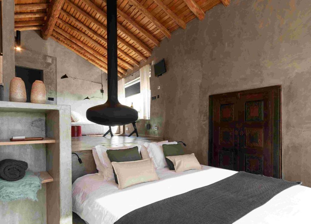 a bedroom with a large bed with a black chandelier at Vigias -Eternal Landscapes in Marvão