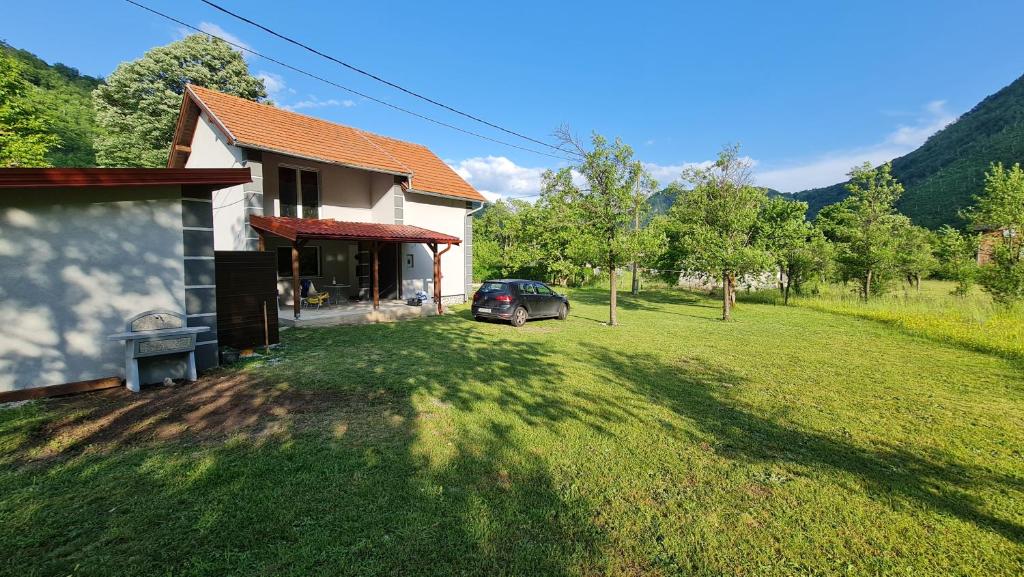 een huis met een auto voor een tuin bij Vila MM Boračko jezero in Konjic