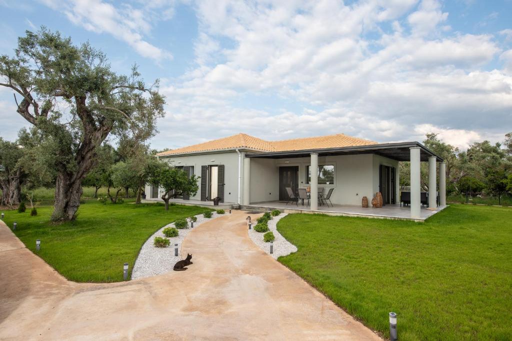 a house with a dog sitting in the driveway at Aerinos private villa in Lefkada Town