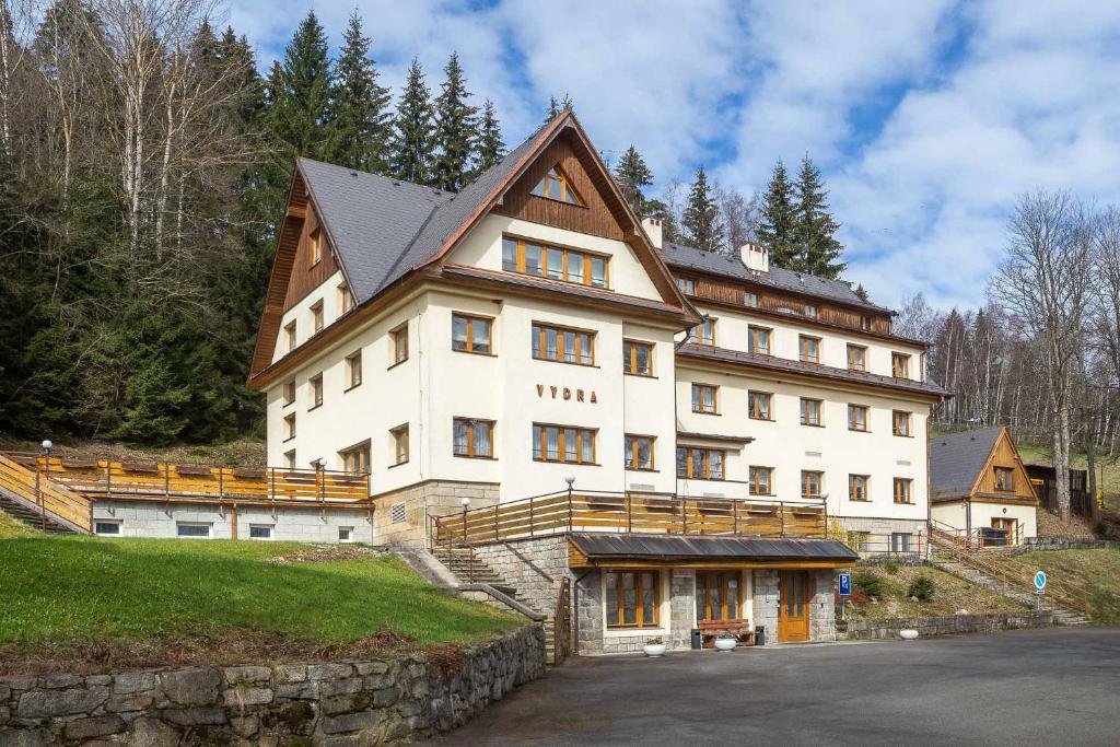 a large white building on top of a hill at Samoobslužný hotel Vydra in Srní