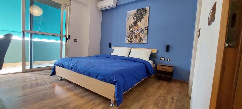 - une chambre bleue avec un lit et une fenêtre dans l'établissement What's Up Tirana, à Tirana