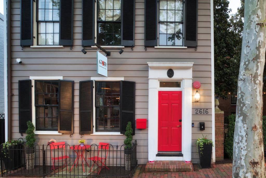 een huis met een rode deur en zwarte ramen bij The Poppy Georgetown Guesthouse and Gardens in Washington