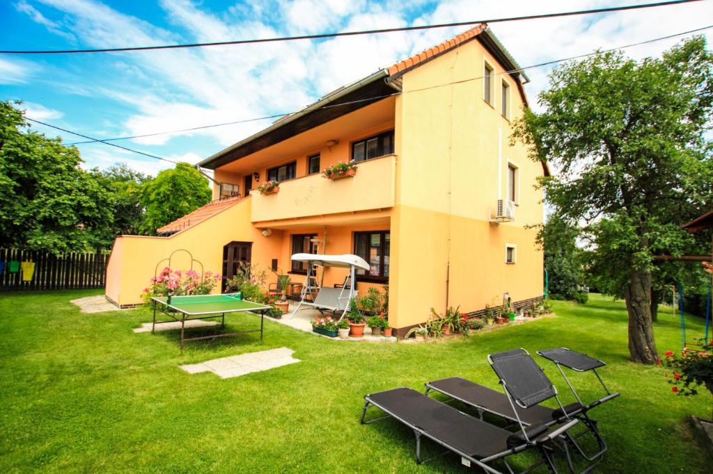 ein Haus mit einem Tisch und Stühlen im Hof in der Unterkunft Penzion Na Vyhlídce in Lukov