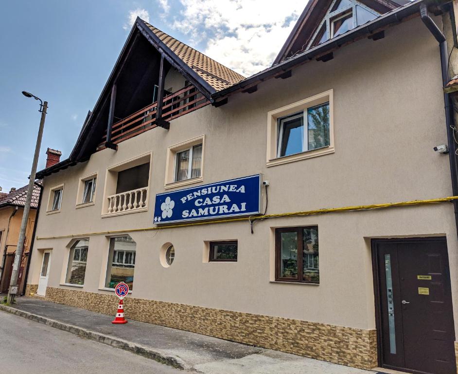 een gebouw met een bord aan de zijkant bij Pension Casa Samurai in Braşov