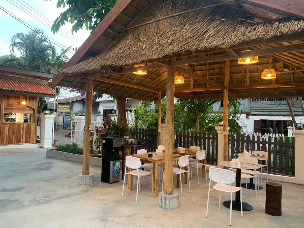 una mesa de madera y sillas bajo un pabellón en La nuit de laos, en Luang Prabang