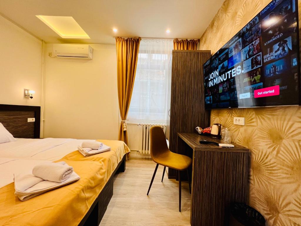 um quarto de hotel com uma cama e uma televisão de ecrã plano em Side One Design Hotel Garni em Belgrado