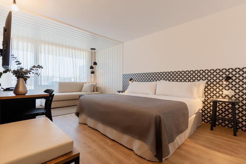 a bedroom with a large bed and a couch at Magnolia Hotel - Adults Only in Salou