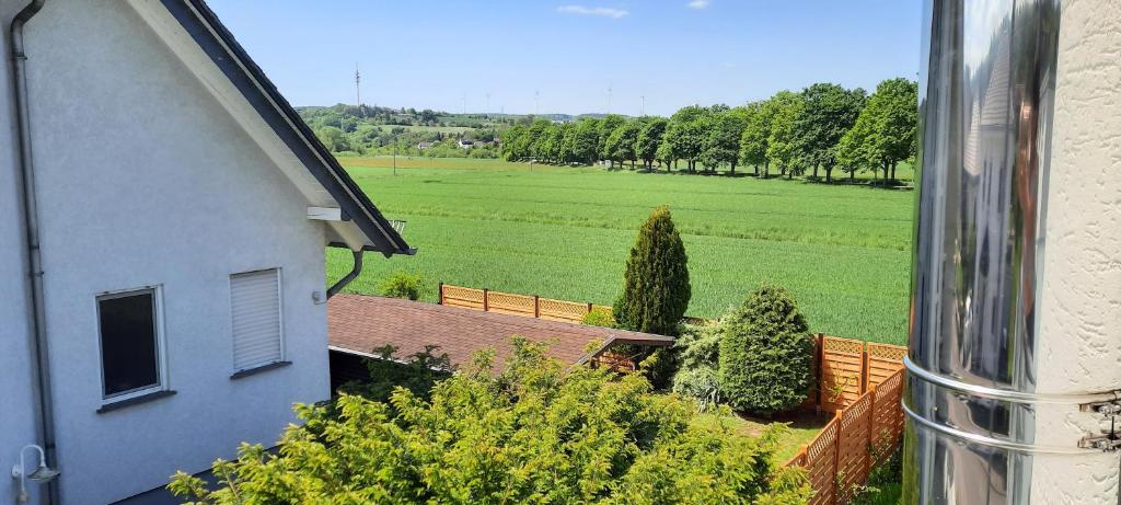 - une vue sur une maison et un champ arboré dans l'établissement Ferienwohnung an der Lahn, à Limburg an der Lahn