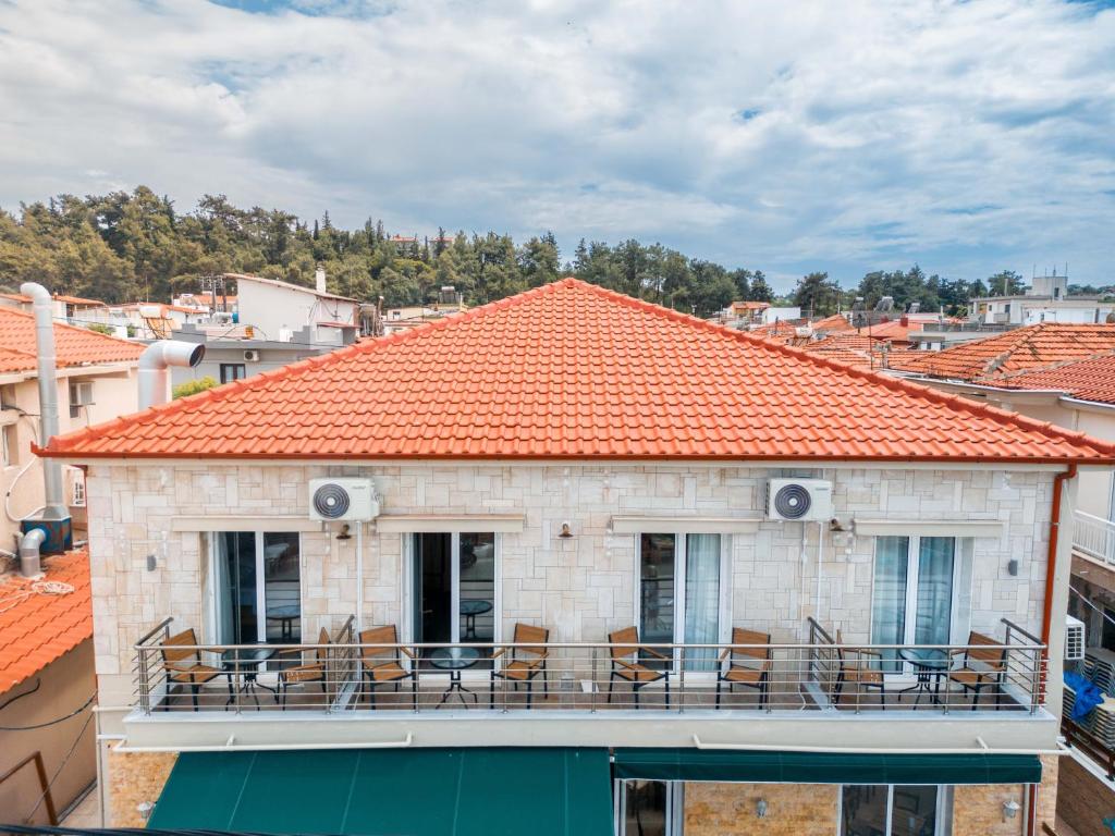 een gebouw met stoelen en een oranje dak bij Casa la Scala in Agia Triada