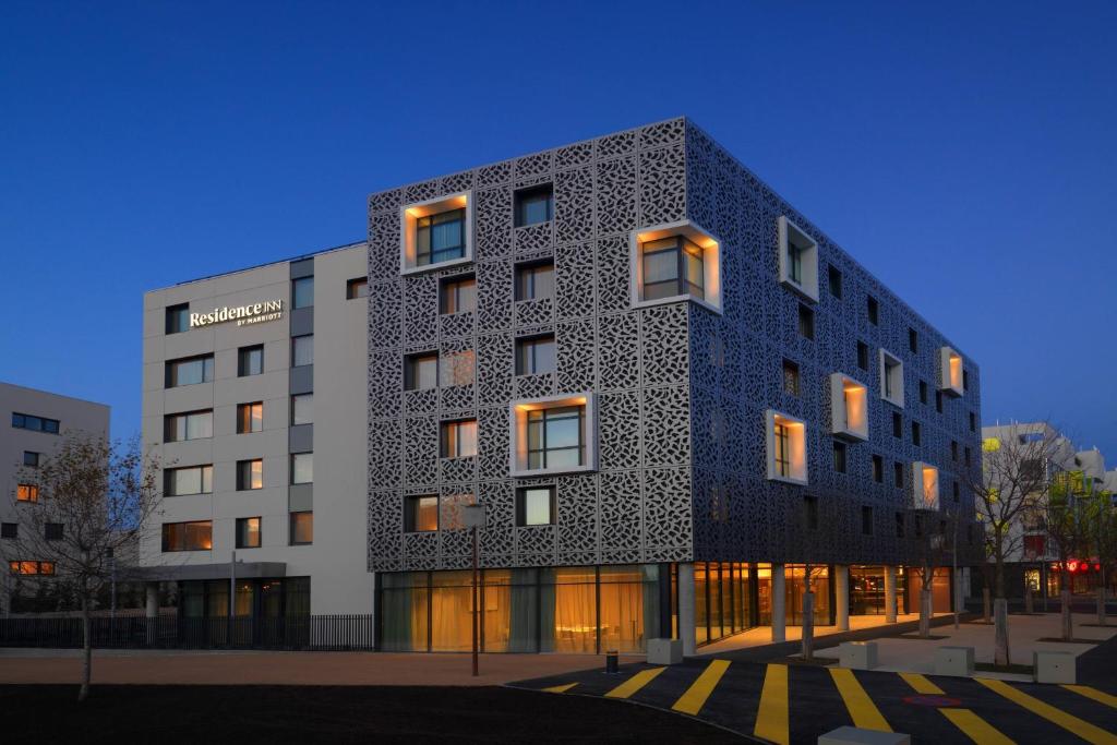 un bâtiment à la façade noire et blanche dans l'établissement Residence Inn by Marriott Toulouse-Blagnac, à Blagnac