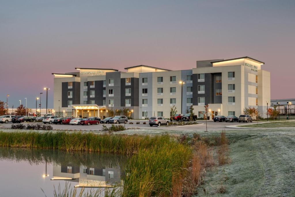 un grande edificio con auto parcheggiate in un parcheggio di TownePlace Suites by Marriott Indianapolis Airport a Indianapolis